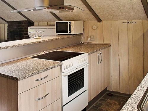 a kitchen with a white stove and a microwave at 6 person holiday home in Hemmet in Falen