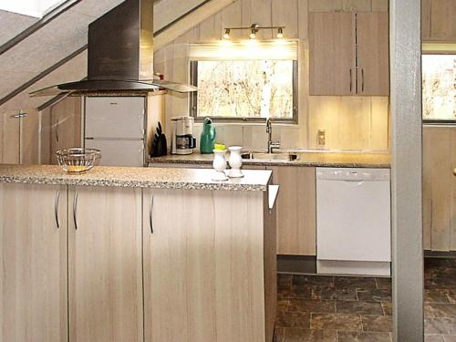 a kitchen with wooden cabinets and a counter top at 6 person holiday home in Hemmet in Falen