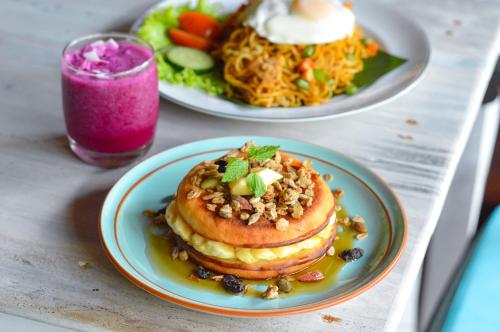 twee borden met pannenkoeken en een drankje bij Tarzan Marriott On Penida in Nusa Penida