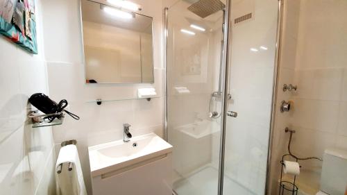 ein weißes Bad mit einer Dusche und einem Waschbecken in der Unterkunft ☆WOW! Stylish Studio in Centre Near University☆ in Mannheim