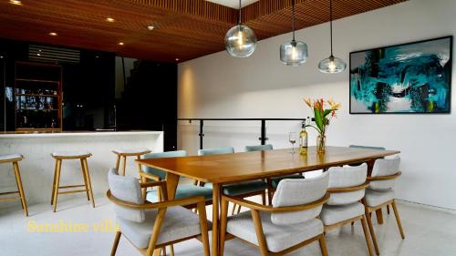 una sala da pranzo con tavolo e sedie in legno di Westcoast PQ Sunshine spacious 3BR private pool villa a Phu Quoc