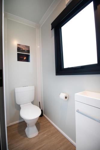 a bathroom with a toilet and a window at The Hideaway - On-site Hot Tub - Close to town in Queenstown