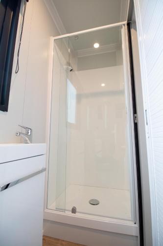 a shower with a glass door in a bathroom at The Hideaway - On-site Hot Tub - Close to town in Queenstown