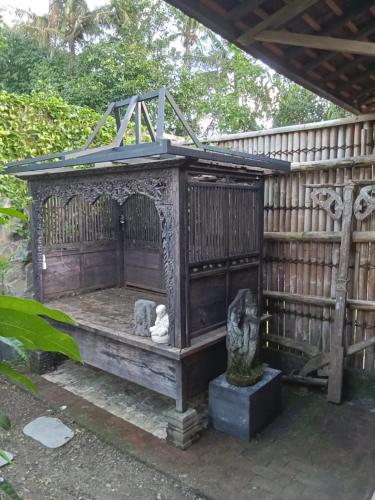 a wooden structure with a bench with a roof at Villa Indi Yogyakarta in Waluadeg