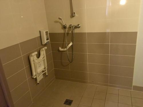 y baño con ducha y suelo de baldosa. en Hotel Bel Alp Manosque en Manosque
