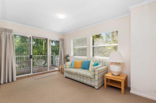 a living room with a couch and windows at Rivershores in Noosaville