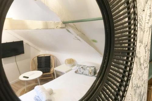 a mirror reflection of a living room in a attic at La Cabane - Petit studio mansardé - Plage 50m - Rue gratuite in Saint Malo