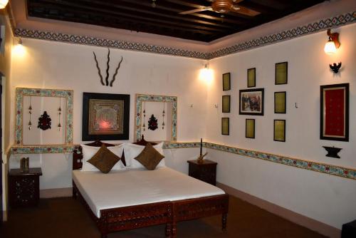 een slaapkamer met een bed en foto's aan de muur bij Haveli in Jodhpur