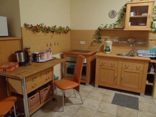 a kitchen with wooden cabinets and a table and chairs at Ferienwohnung am Nurburgring in Welcherath