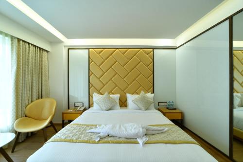 a hotel room with a bed with a towel on it at The President Hotel, kumarapark in Bengaluru