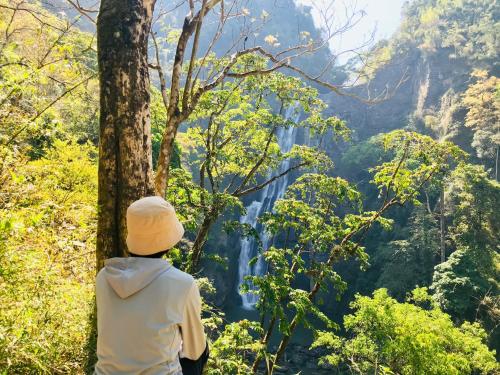 a man standing in front of a waterfall in a forest at Mộc Lan’s House in Phi Liêng