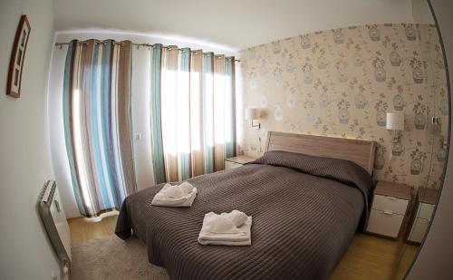 a bedroom with a bed with two towels on it at Predela 2 Aparthotel in Bansko