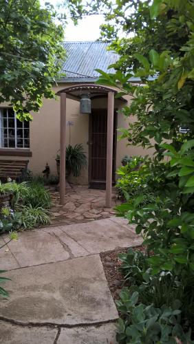a small house with a porch with a door at Selah guest cottage...place to pause, breath relax in Bethulie