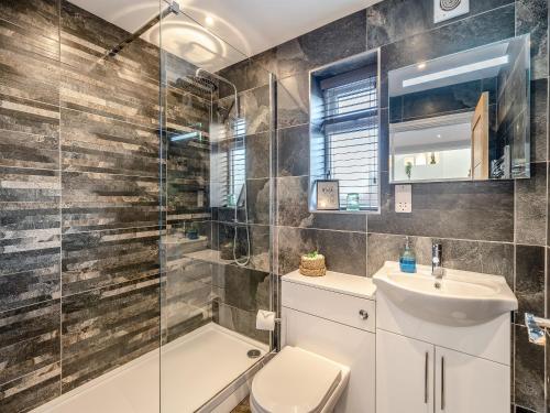 a bathroom with a shower toilet and a sink at Ferndale Bungalow in Hambleton