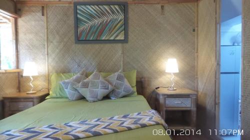 Un dormitorio con una cama verde con almohadas. en Paraiso Cave & Restaurant & Resort en San Francisco