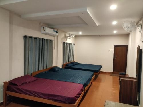 een slaapkamer met 2 bedden in een kamer bij Azhar lodge koyilandy in Kozhikode