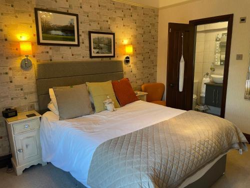 a bedroom with a bed with a teddy bear sitting on it at Glenville House - Adults Only - Incl FREE off-site health club with swimming pool, hot tub, sauna & steam room in Windermere