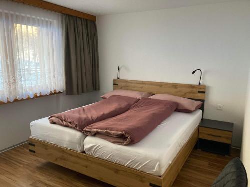 薩斯阿爾馬格爾的住宿－Haus Castello，一间卧室配有一张带两个枕头的木床
