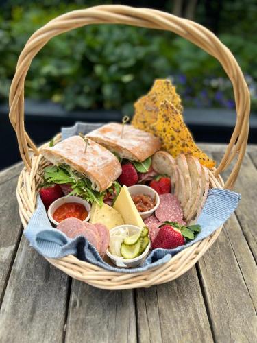 a basket full of food on a wooden table at The Amberley Hotel in Amberley