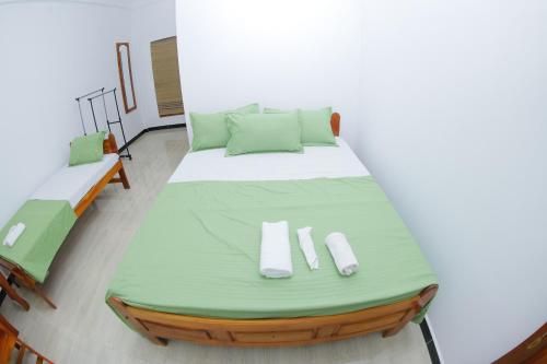 ein großes Bett in einem Zimmer mit 2 Betten in der Unterkunft Amis Hotel & Restaurant in Jaffna