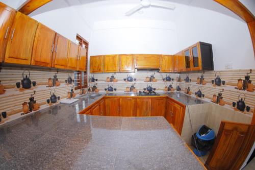 a kitchen with wooden cabinets and a counter top at Amis Hotel & Restaurant in Jaffna