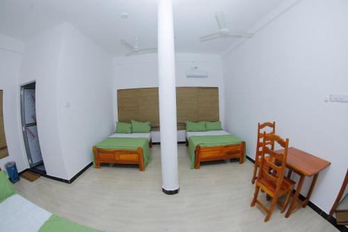 a room with a bed and a table and chairs at Amis Hotel & Restaurant in Jaffna
