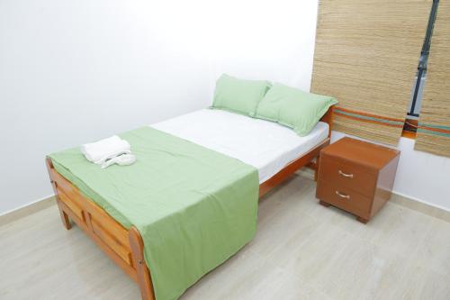 a small bedroom with a bed and a night stand at Amis Hotel & Restaurant in Jaffna