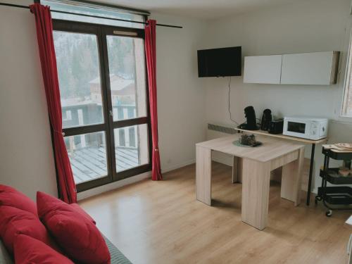 a living room with a table and a microwave at Jolies Appartement 6 couchages a praloup 1600 avec balcons in Uvernet-Fours