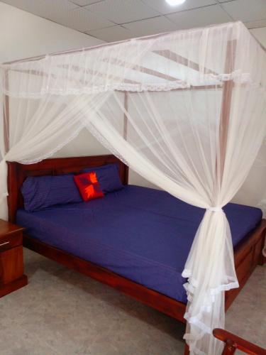 a bedroom with a bed with a canopy at Sandew Residence in Tangalle