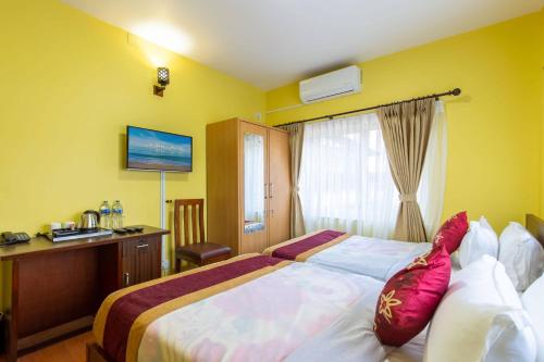 a hotel room with a large bed and a desk at Deepjyoti Inn in Pashupatināth
