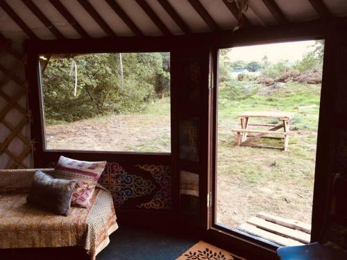 a room with a view of a picnic table through a window at Mongolian yurt sleeping 2+2 with outdoor space in Llanbrynmair