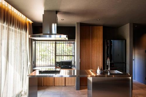 a kitchen with a sink and a stove at Itoshima 810 Villa & Resort in Keya