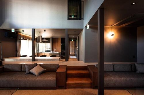 ein Wohnzimmer mit einem Sofa und einer Küche in der Unterkunft Itoshima 810 Villa & Resort in Keya