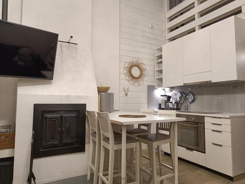 een keuken met een tafel en stoelen en een open haard bij Syöte Luppomaja in Syöte