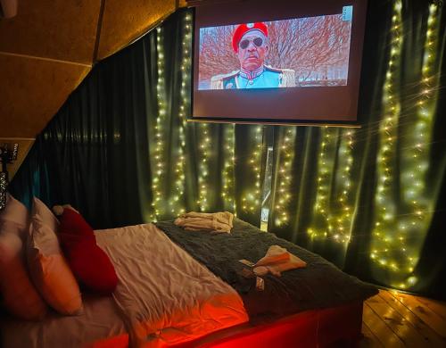 a bedroom with a bed with a television with lights at Paradise Inn in Batumi