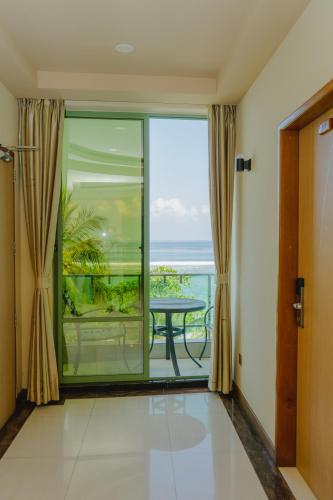 a room with a balcony with a view of the ocean at Season Holidays at Hulhumale with Transfer in Hulhumale