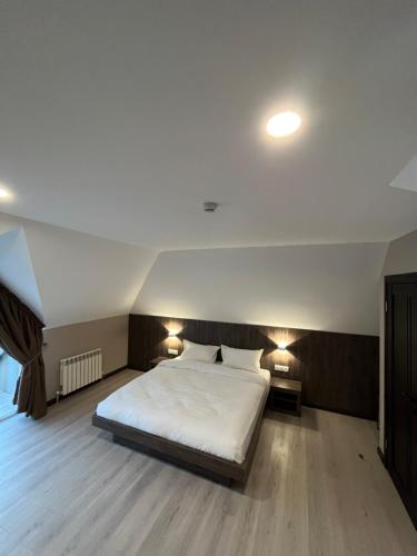 a bedroom with a large white bed with two lamps at Resident Hotel Kaskelen in Kaskelen