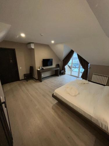 a bedroom with a large bed and a television at Resident Hotel Kaskelen in Kaskelen