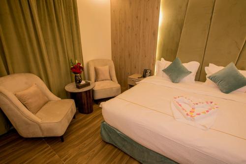 a hotel room with a bed and two chairs at Luxury Night Al Mounisea in Riyadh