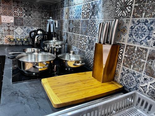 a kitchen with pots and pans and a wooden cutting board at Dar Barbara - Duplex 1 Double bedroom Maisonette in Cospicua