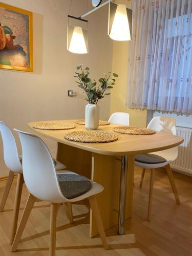 a dining room table with chairs and a vase on it at Ferienwohnung Vater Rhein Mittelrheintal in Sankt Goar