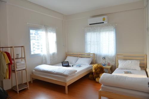 Un dormitorio con 2 camas y un osito de peluche. en PanPan Hostel, en Bangkok