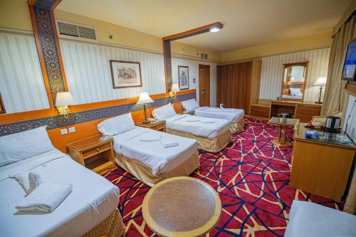 een hotelkamer met twee bedden en een tafel bij فندق مسك ام القرى Misk Umm Al Qura Hotel in Mekka