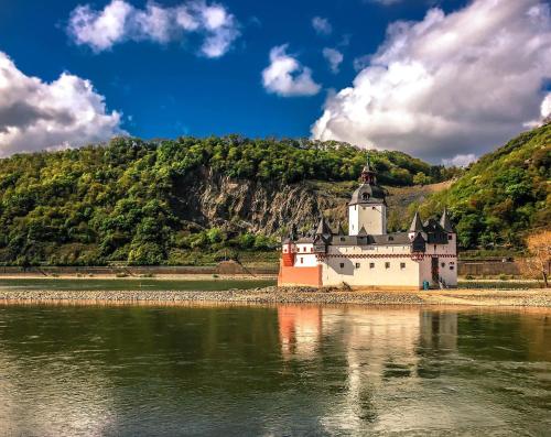 a castle on the shore of a body of water at Ferienwohnung Loreley Mittelrheintal in Sankt Goar