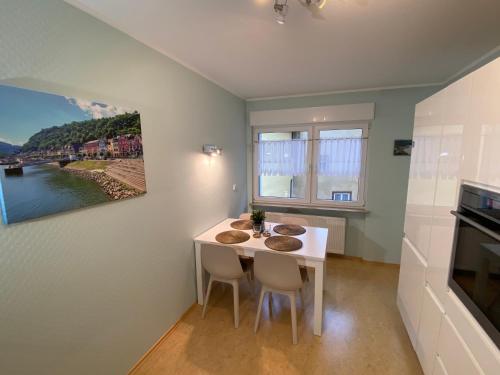 a small kitchen with a white table and chairs at Ferienwohnung Loreley Mittelrheintal in Sankt Goar
