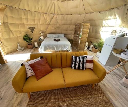 un sofá amarillo con almohadas en una habitación en Sage Desert Dreams, en Las Vegas