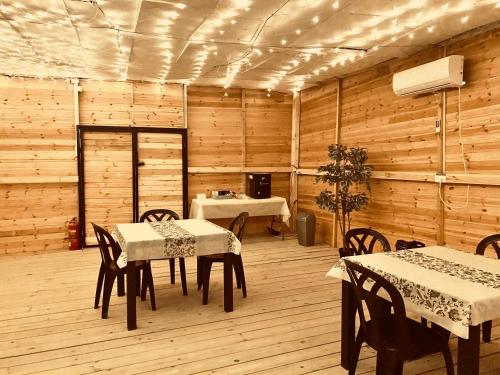 una sala da pranzo con tavoli, sedie e pareti in legno di נירוונה במדבר a Be'er Milka