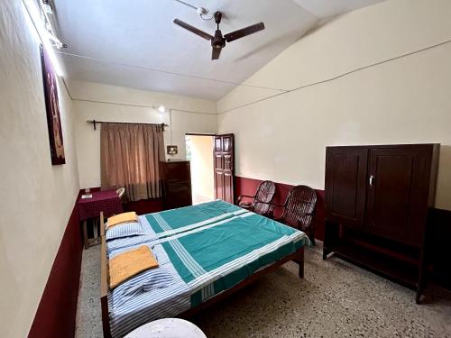ein Schlafzimmer mit einem Bett und einem Deckenventilator in der Unterkunft 'O' Palmar Beach Cottages Benaulim in Benaulim