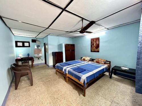 ein Schlafzimmer mit einem Bett und einem Schreibtisch darin in der Unterkunft 'O' Palmar Beach Cottages Benaulim in Benaulim