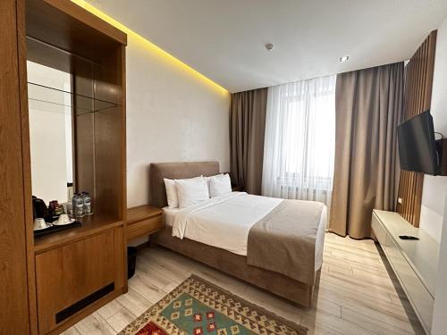 a hotel room with a bed and a television at HOTEL MODERNO & Spa in Tashkent